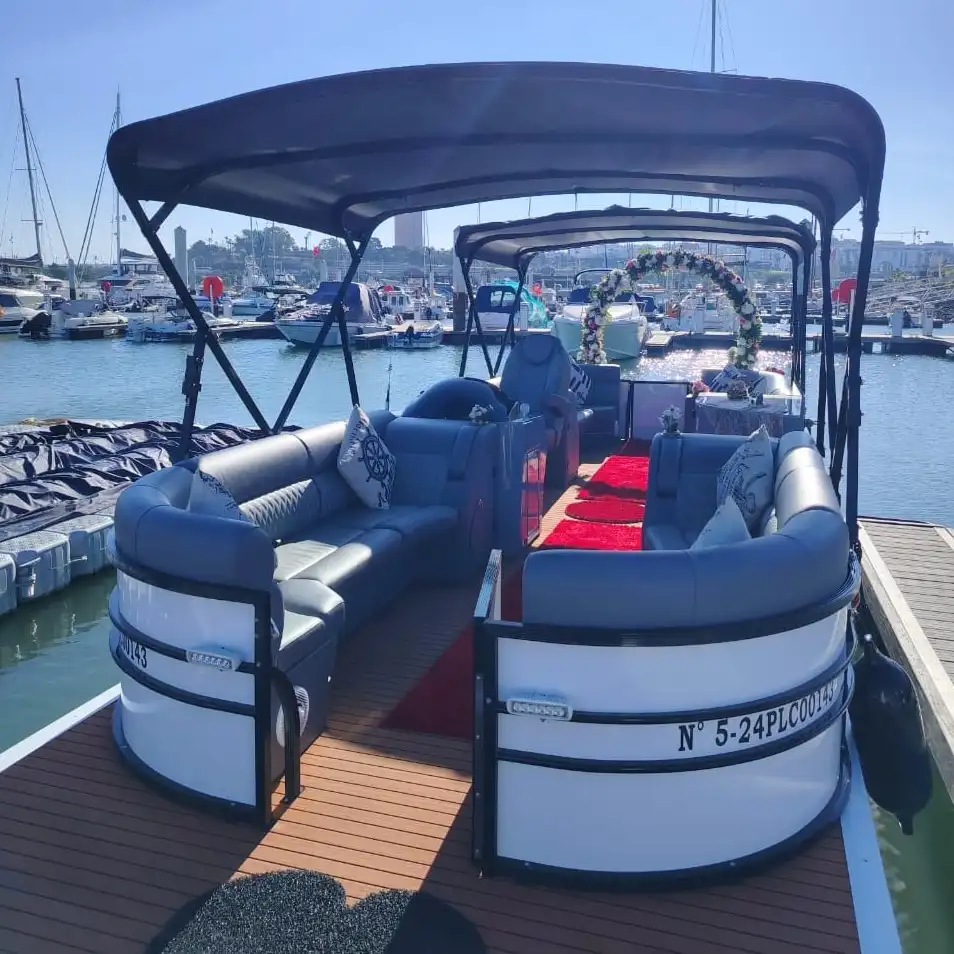 Luxurious boat with stylish seating and a canopy docked in a marina, surrounded by other boats under a clear blue sky