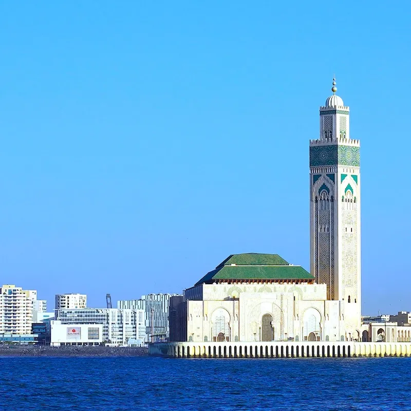 Hassan II Mosque in Casablanca, Morocco, overlooking the Atlantic Ocean with modern cityscape in the background