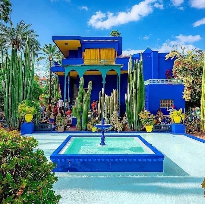 Majorelle Garden in Marrakech, Morocco, featuring vibrant blue architecture, lush greenery, and a tranquil water fountain