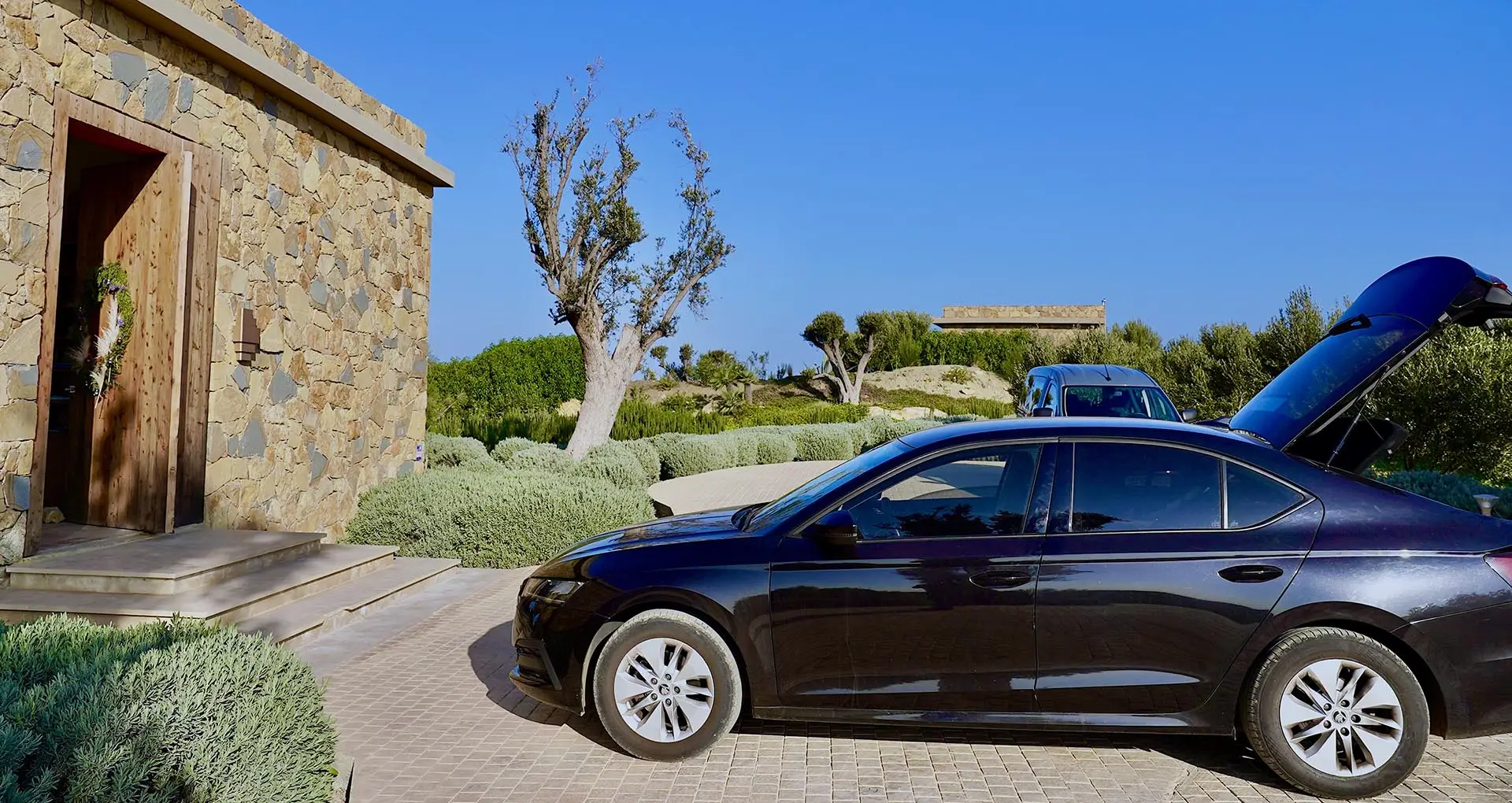 Luxury car parked in front of a resort reception, expecting a couple for a transfer, provided by Morocco Tours & Transfers